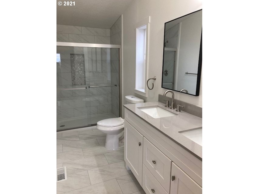 46368 Durham Place Pendleton, OR 97801 - Photo 11 of 32 a bathroom with a granite countertop sink a toilet and a mirror