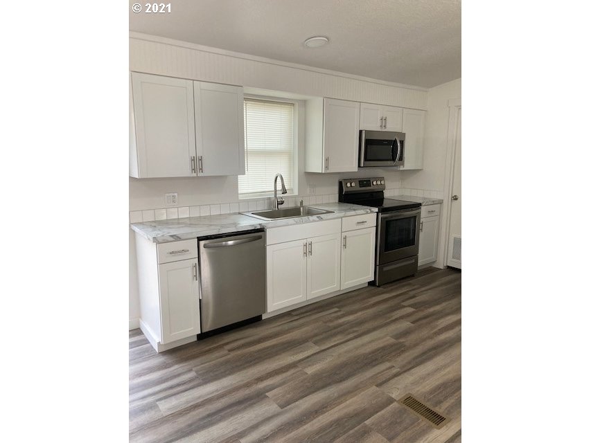 46368 Durham Place Pendleton, OR 97801 - Photo 5 of 32 a kitchen with a sink cabinets and stainless steel appliances