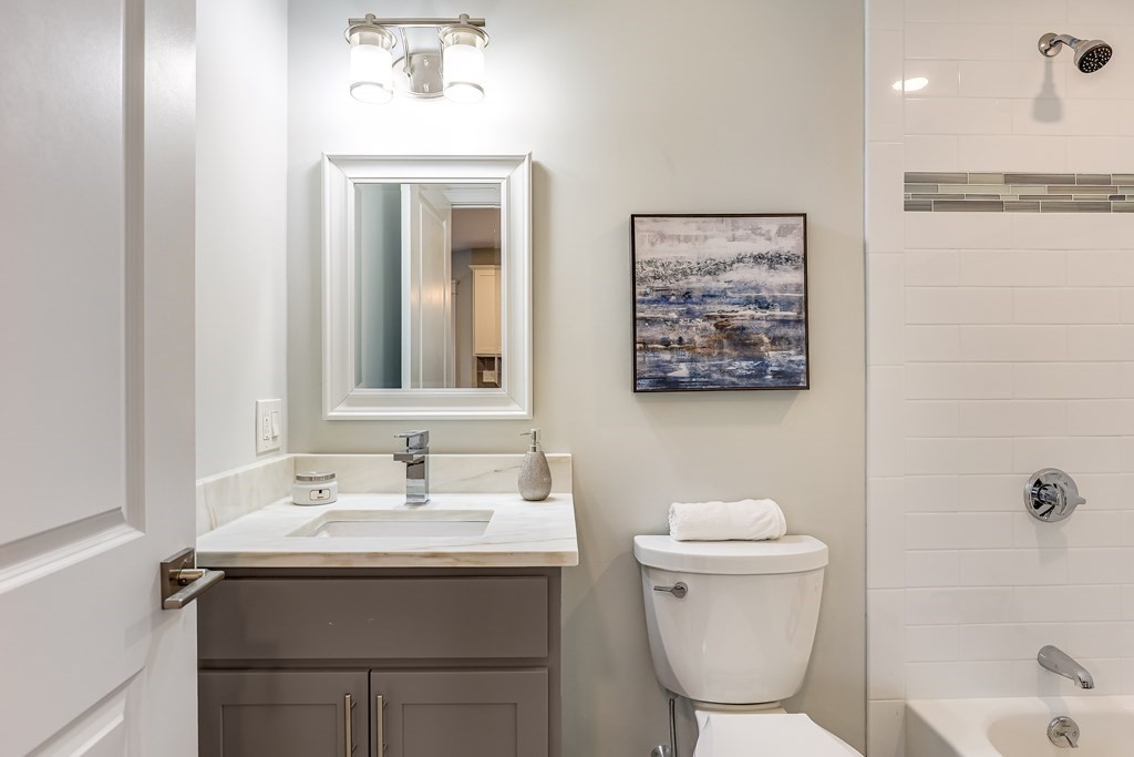 94 Marathon Street, Unit 1 Arlington, MA 02474 - Photo 16 of 24 a bathroom with a toilet sink and mirror