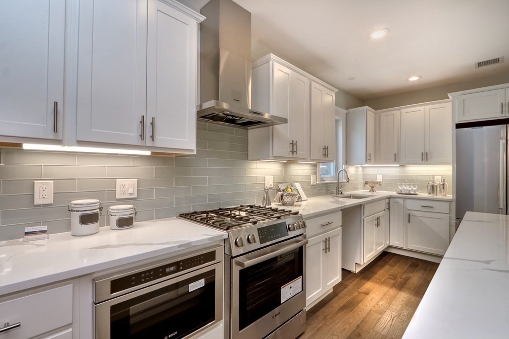 94 Marathon Street, Unit 1 Arlington, MA 02474 - Photo 6 of 24 a kitchen with stainless steel appliances a sink a stove and cabinets