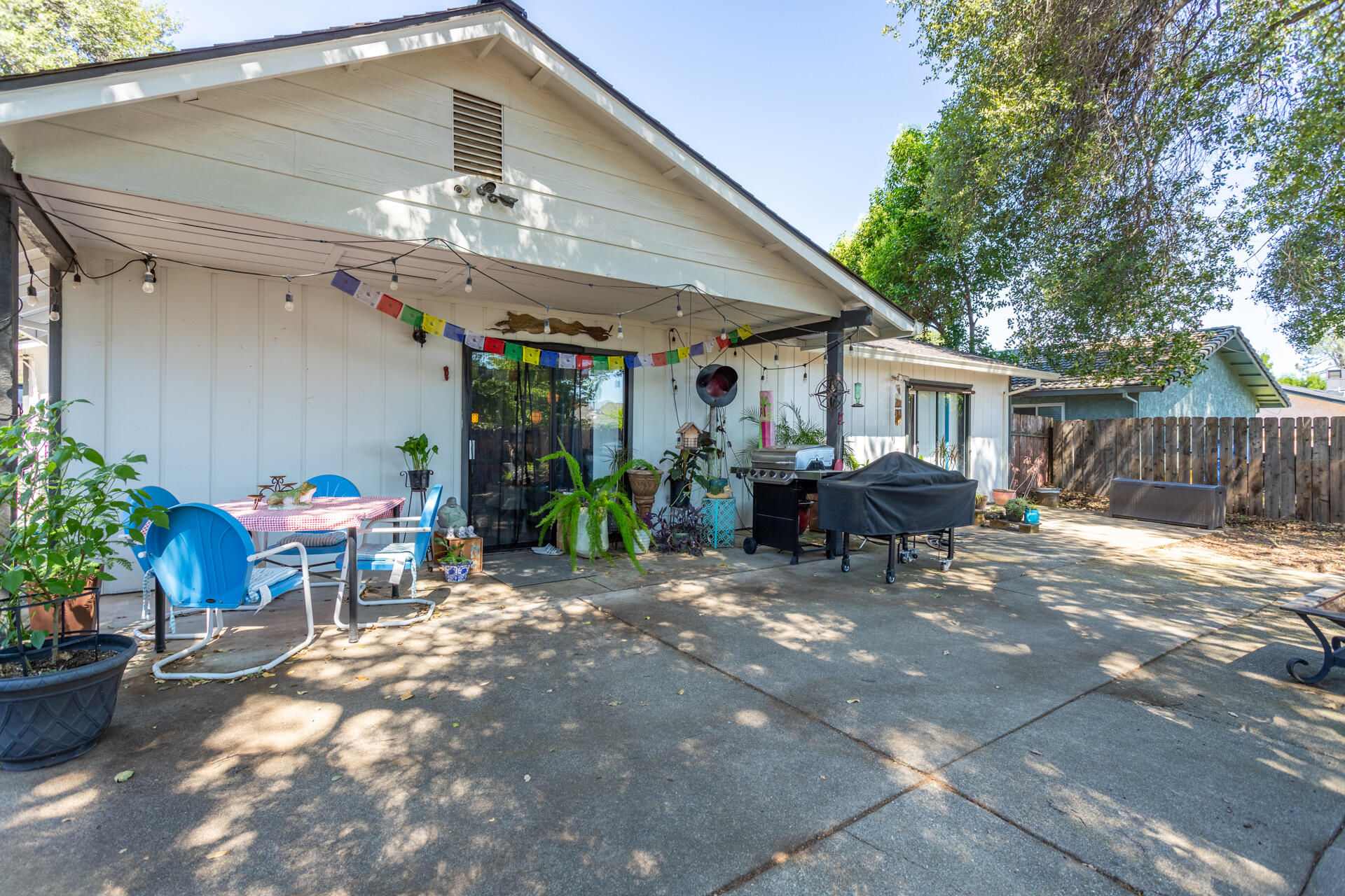 1274 Harpole Road Redding, CA 96002 - Photo 19 of 27 a view of a patio with table and chairs potted plants and floor to ceiling window