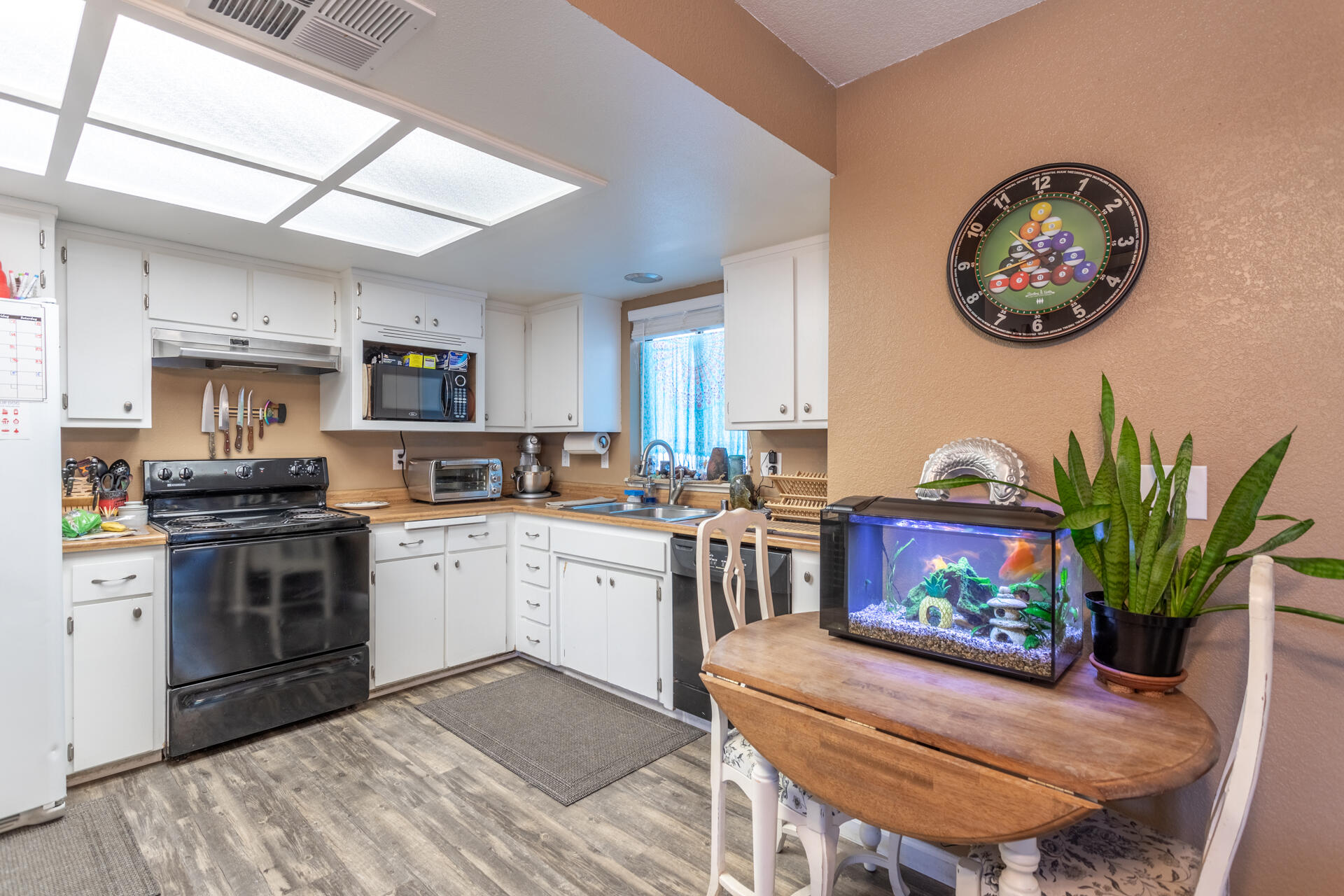 1274 Harpole Road Redding, CA 96002 - Photo 3 of 27 a kitchen with stainless steel appliances granite countertop a stove top oven a sink a dining table and chairs