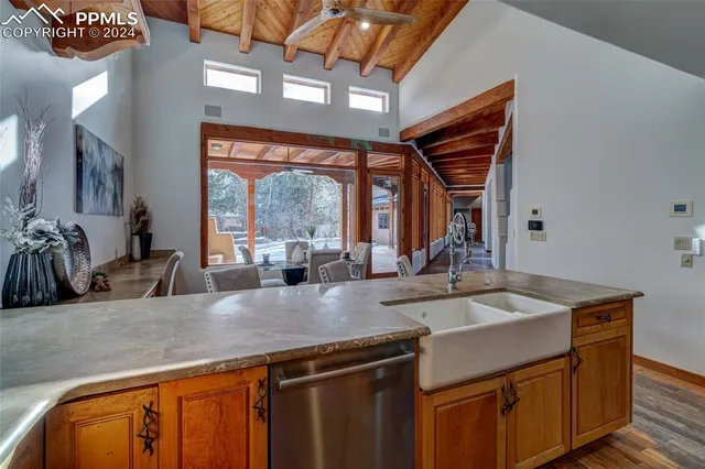 a kitchen with stainless steel appliances granite countertop a sink a counter space and a view of living room