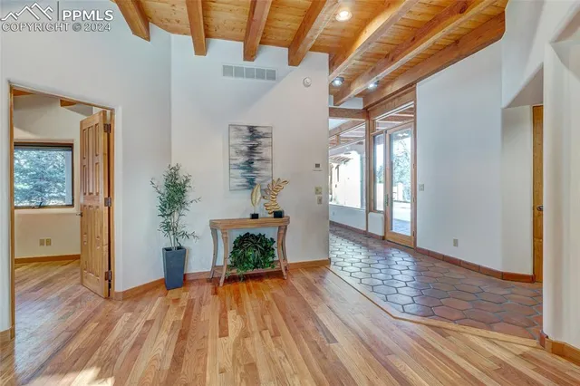 a room with wooden floor and windows