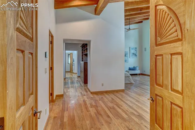 a view of a hallway with wooden floor and staircase