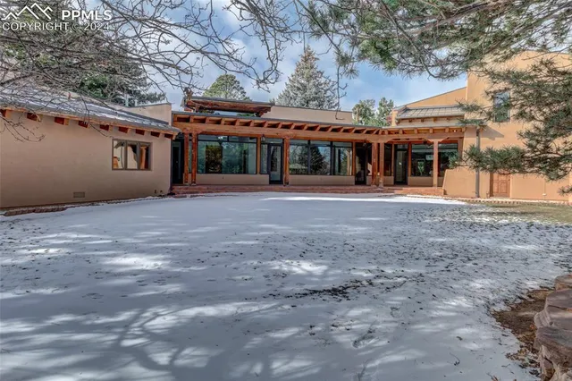 a front view of a house with a big yard and large tree