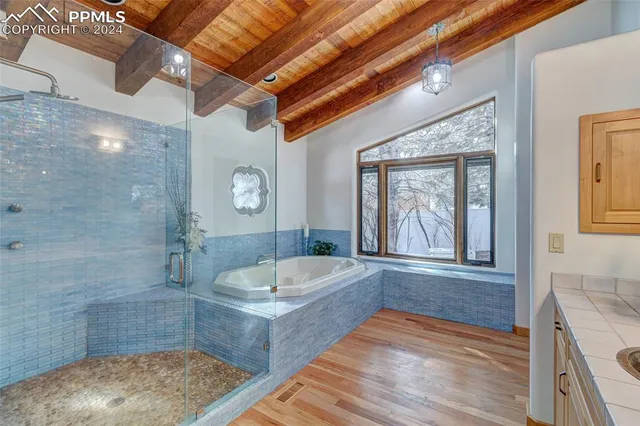 a bathroom with a tub a sink and a large mirror