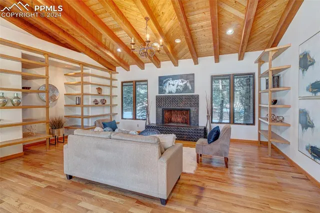 a living room with furniture a fireplace and a large window