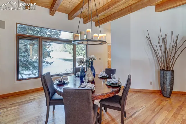 a dining room with furniture a chandelier and wooden floor