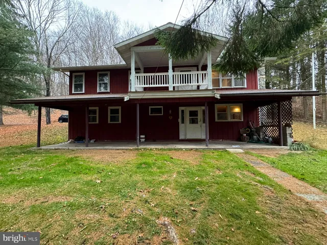 a front view of a house with a garden and trees