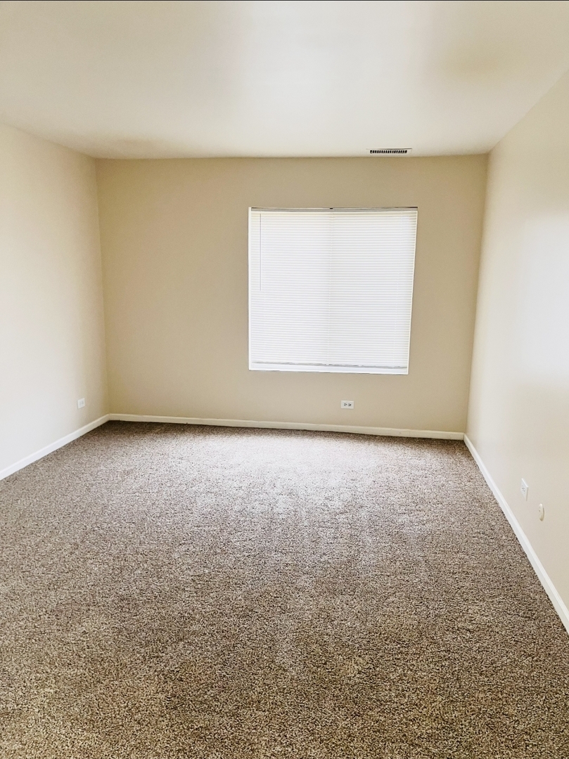 612 Waterford Road South, Unit 1B Schaumburg, IL 60193 - Photo 6 of 10 an empty room with a window