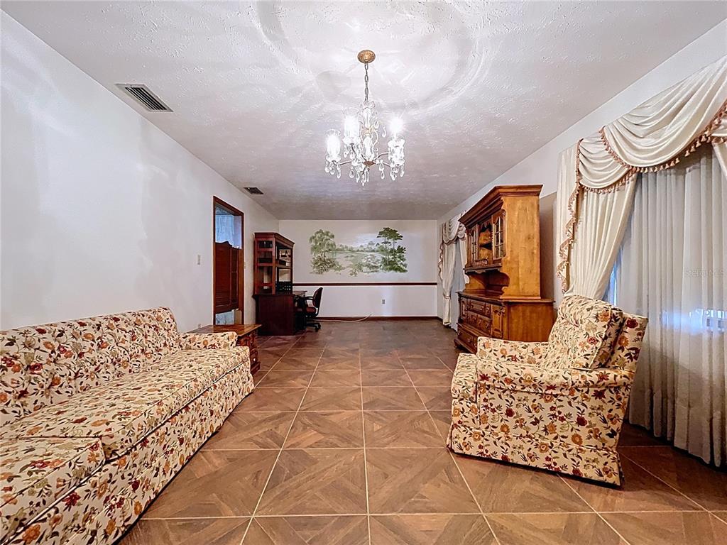 9471 McIntosh Road Dover, FL 33527 - Photo 10 of 34 a living room with furniture and a chandelier