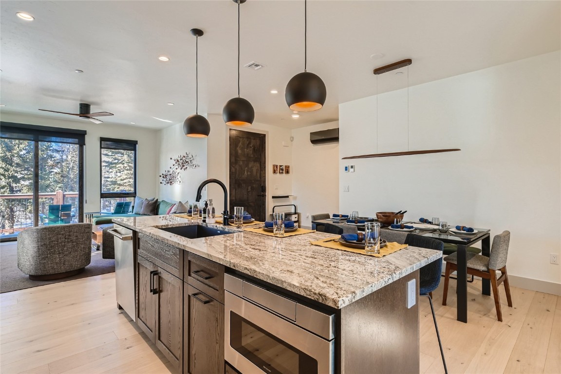 46 6th Street, Unit A1 Silverthorne, CO 80498 - Photo 10 of 28 a kitchen with stainless steel appliances granite countertop a stove a sink and a dining table with granite countertop chairs