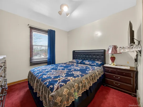 a bedroom with a bed and a flat tv screen on the dresser