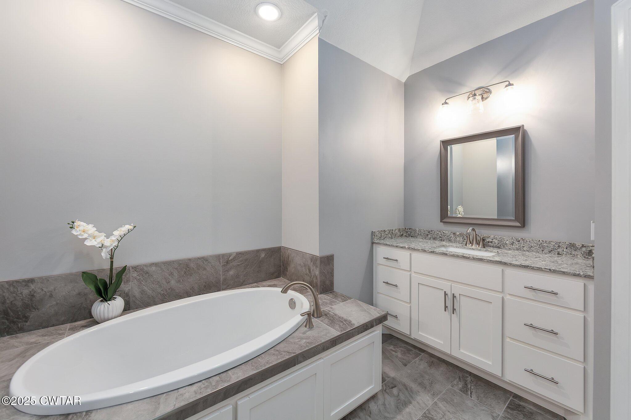 63 Westcott Cove Jackson, TN 38305 - Photo 18 of 31 a bathroom with a granite countertop sink a toilet and mirror
