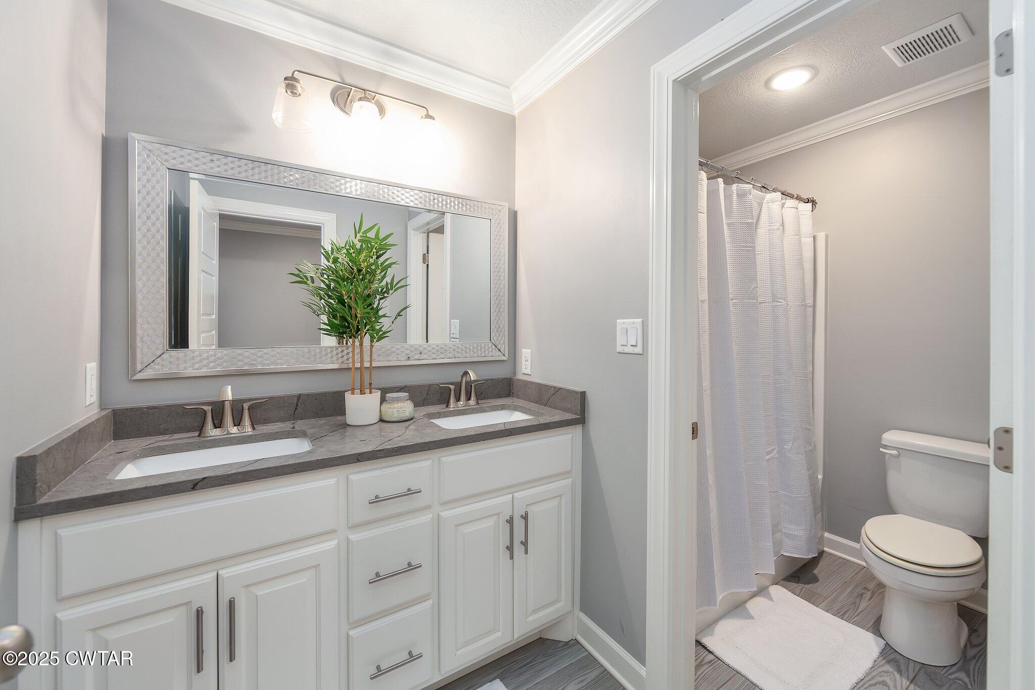 63 Westcott Cove Jackson, TN 38305 - Photo 23 of 31 a bathroom with a granite countertop sink a toilet and a mirror