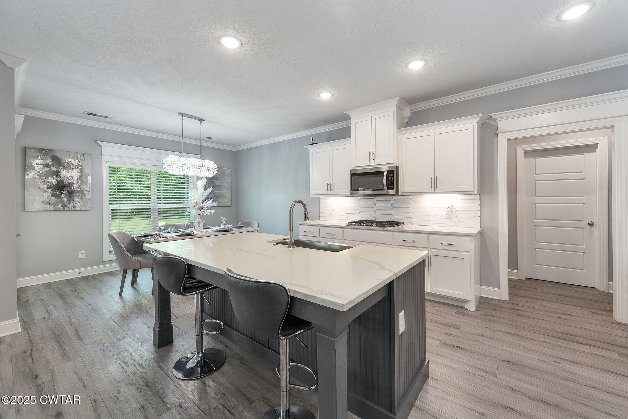 63 Westcott Cove Jackson, TN 38305 - Photo 6 of 31 a kitchen with a table chairs sink and cabinets