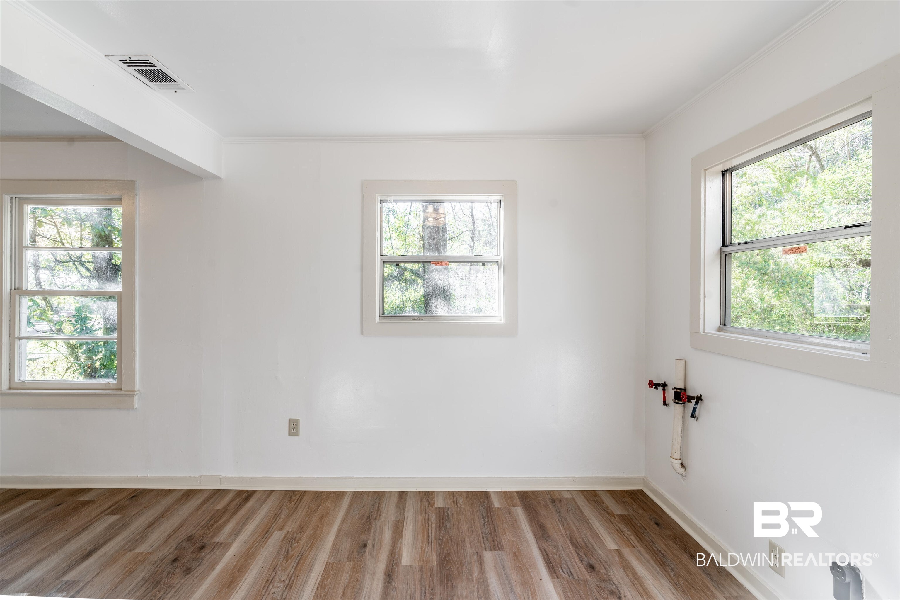 3900 Brookmont Drive Mobile, AL 36605 - Photo 9 of 19 Empty room featuring light wood-type flooring, plenty of natural light, and ornamental molding