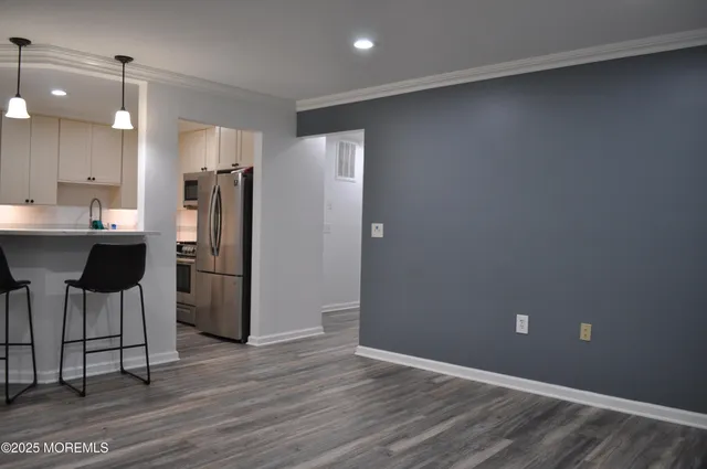 a kitchen with stainless steel appliances a refrigerator and wooden floor