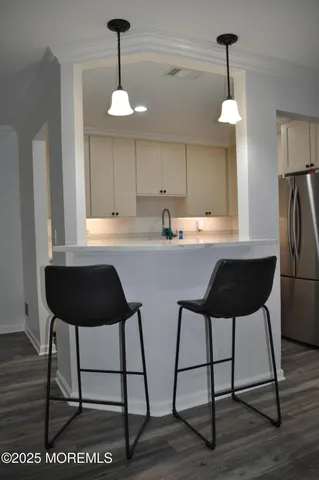 a kitchen with stainless steel appliances a dining table chairs and a refrigerator