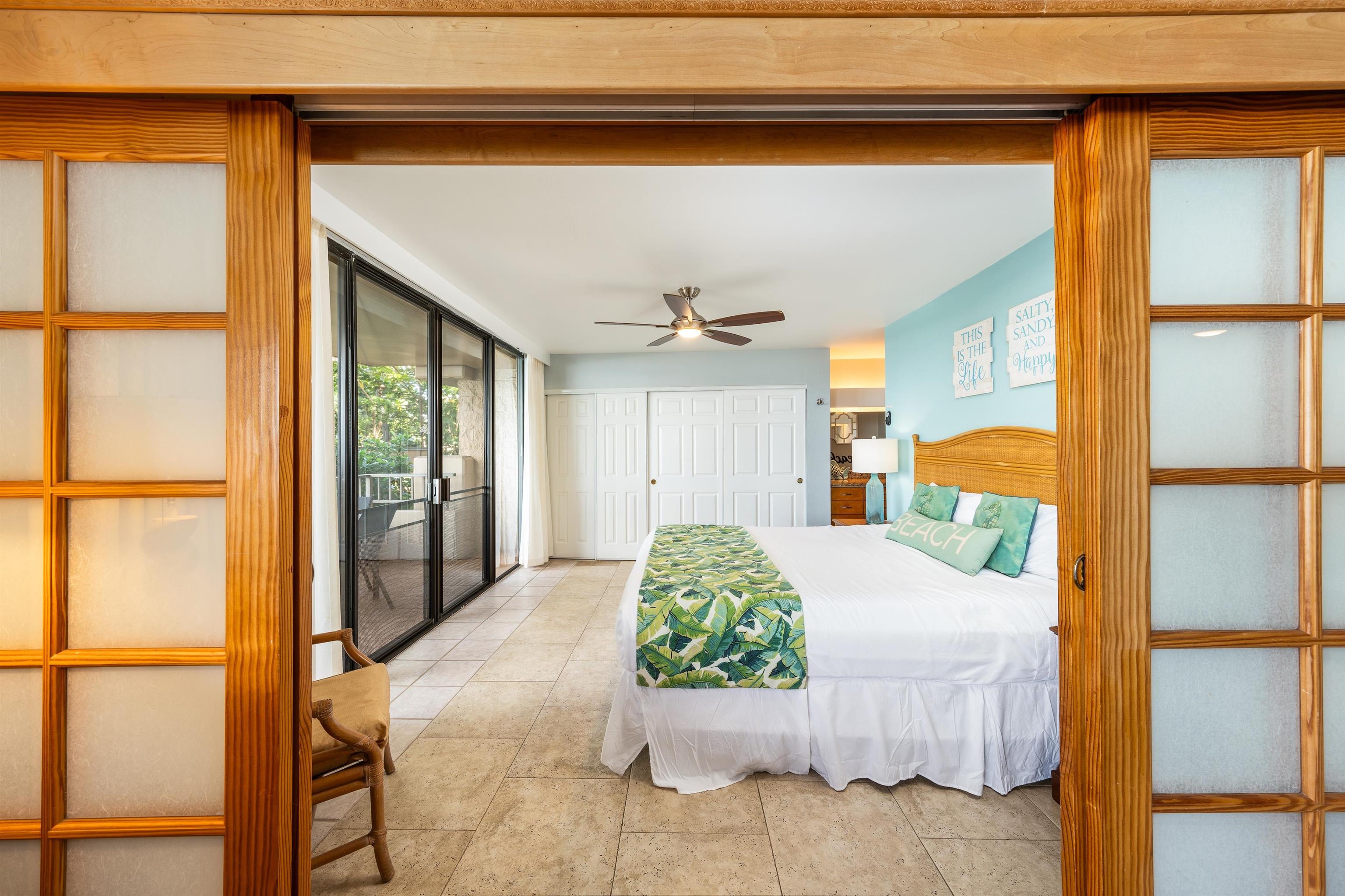 3615 Lower Honoapiilani Road, Unit 123 Lahaina, HI 96761 - Photo 27 of 41 a bedroom with a large bed and a chandelier