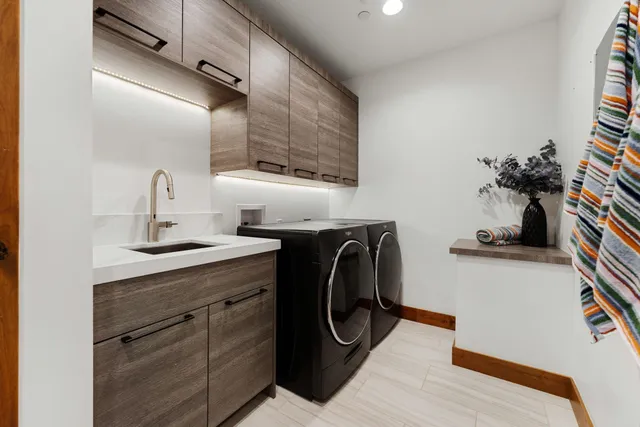 a utility room with sink dryer and washer