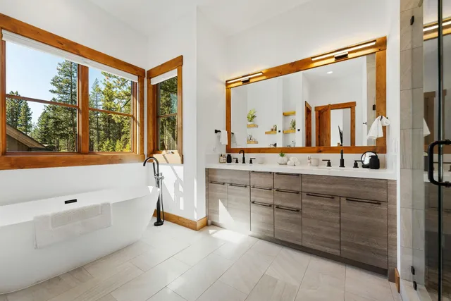 a bathroom with a double vanity sink mirror and bathtub