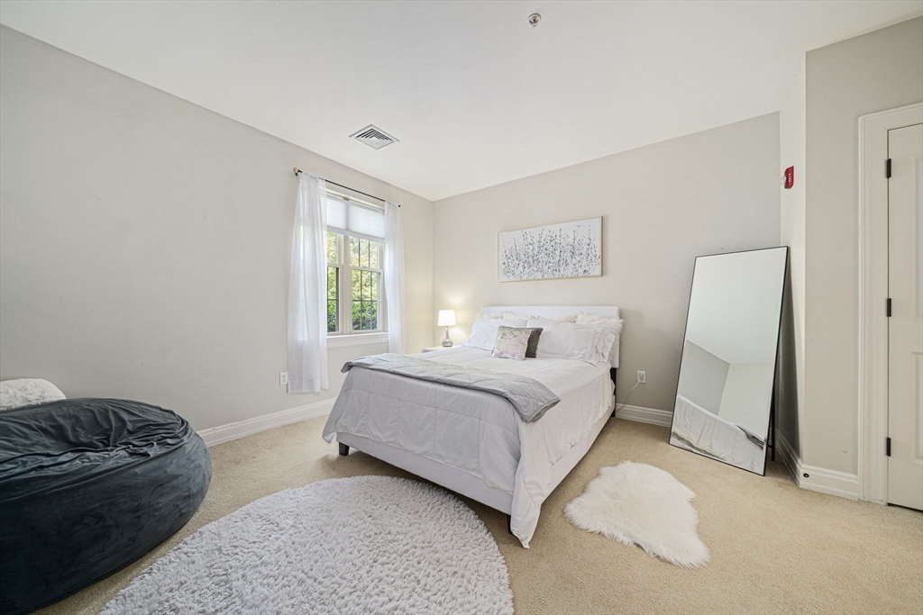 59 Walpole Street, Unit 115 Canton, MA 02021 - Photo 15 of 41 a spacious bedroom with a bed and a couch
