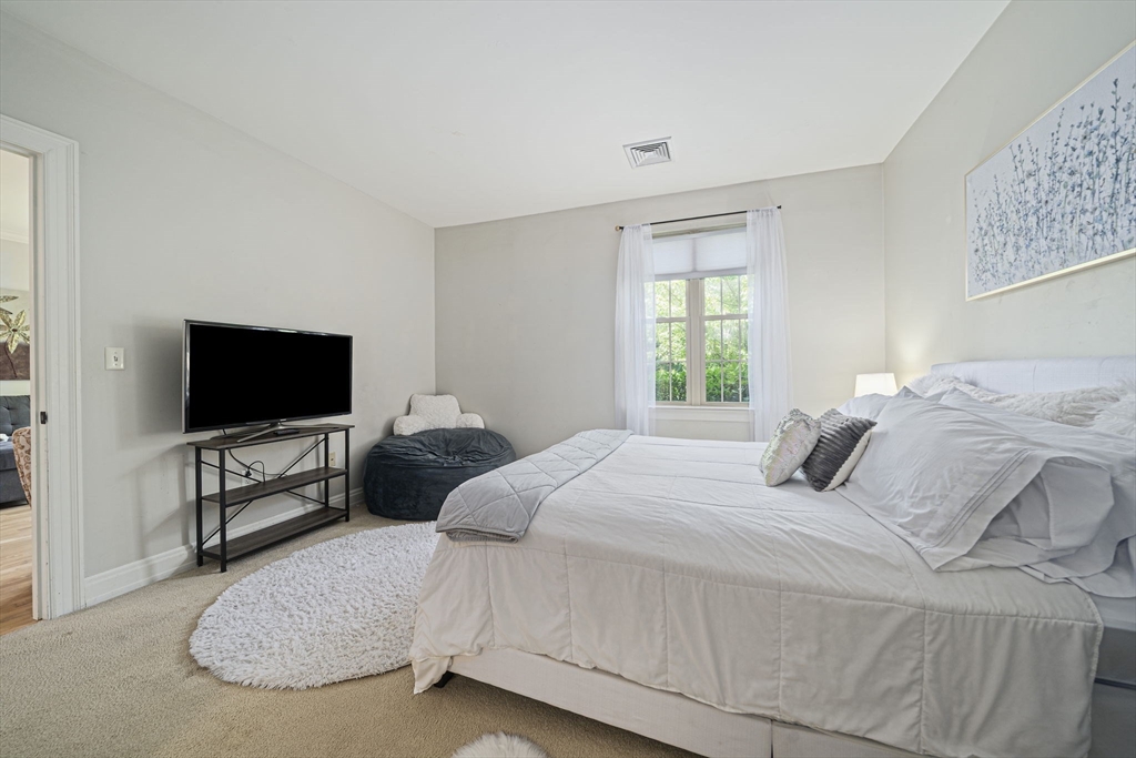 59 Walpole Street, Unit 115 Canton, MA 02021 - Photo 17 of 41 a bedroom with a bed and a flat screen tv