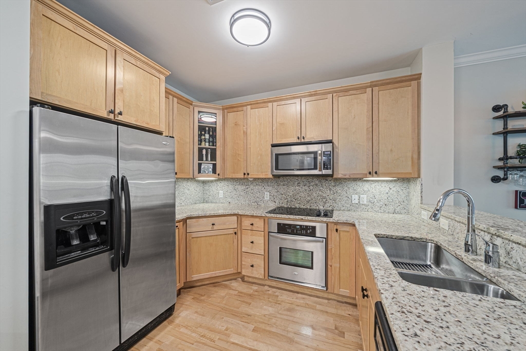 59 Walpole Street, Unit 115 Canton, MA 02021 - Photo 4 of 41 a kitchen with stainless steel appliances granite countertop a stove a sink and a refrigerator