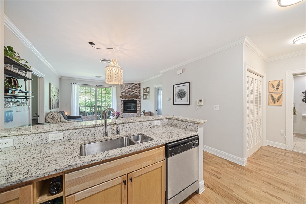 59 Walpole Street, Unit 115 Canton, MA 02021 - Photo 5 of 41 a kitchen with granite countertop a sink and a stove with wooden floor