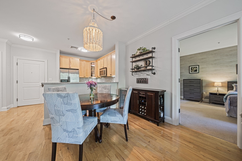 59 Walpole Street, Unit 115 Canton, MA 02021 - Photo 7 of 41 a dining room with furniture a chandelier and wooden floor