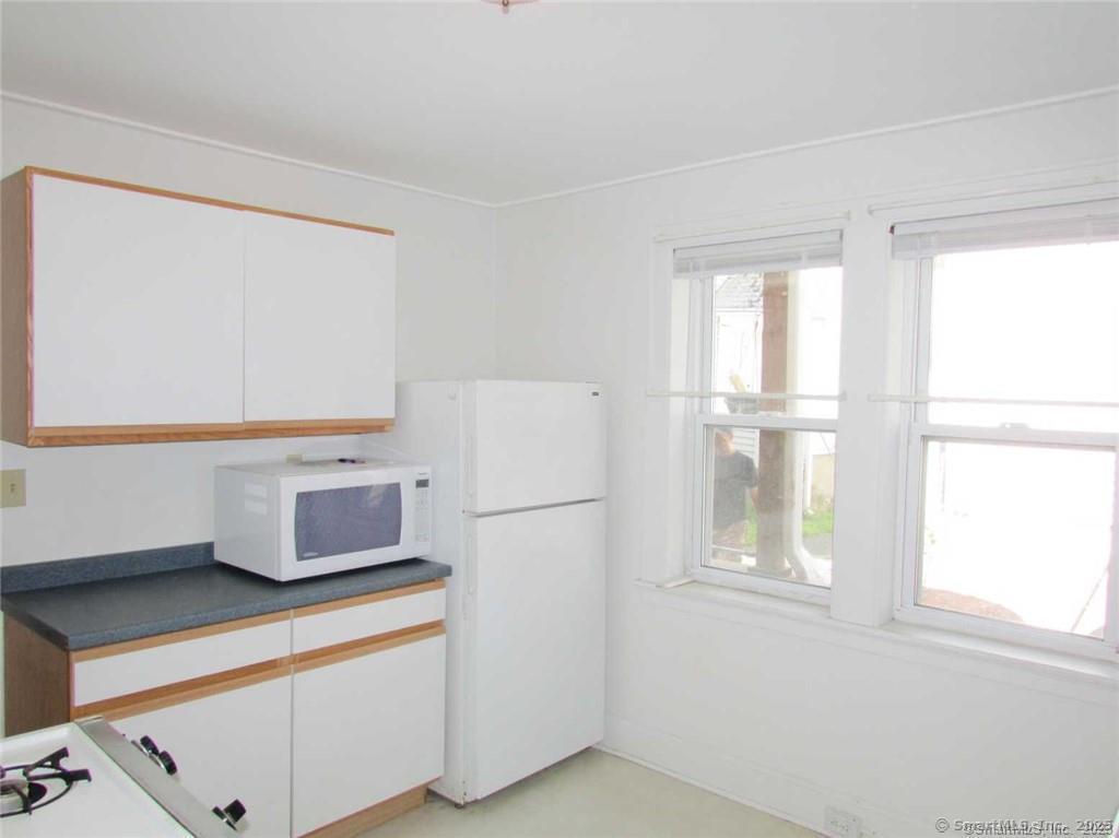44 Brookside Avenue, Unit U2 Torrington, CT 06790 - Photo 3 of 10 a white refrigerator freezer sitting next to a window