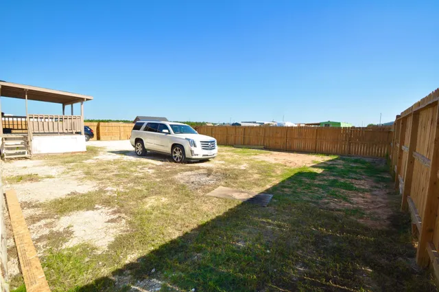 a view of backyard with swimming pool and seating area