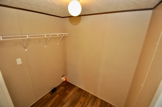 an empty room with wooden floor and a window