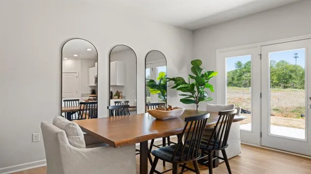 a dining room with furniture potted plants and wooden floor