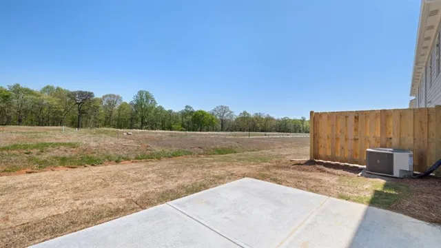 a living room with furniture a flat screen tv and kitchen view