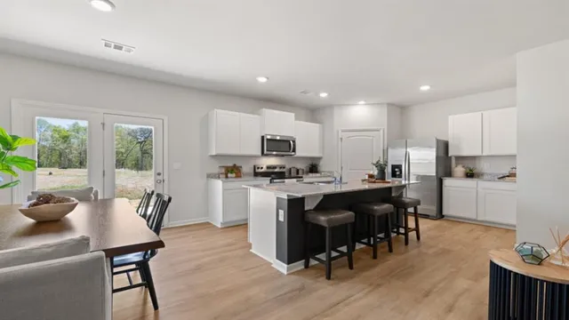 a kitchen with a sink stainless steel appliances and white cabinets