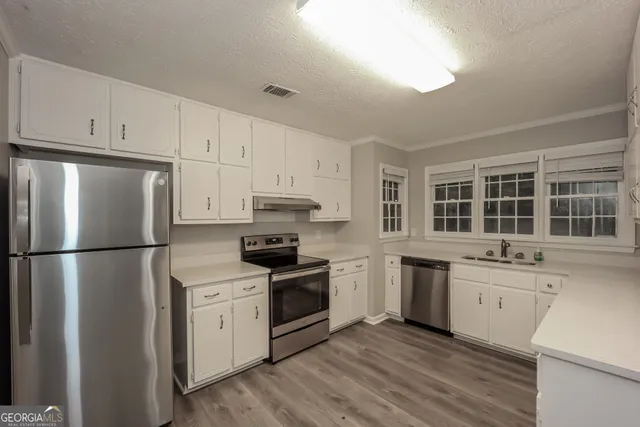 a kitchen with stainless steel appliances a refrigerator sink and cabinets