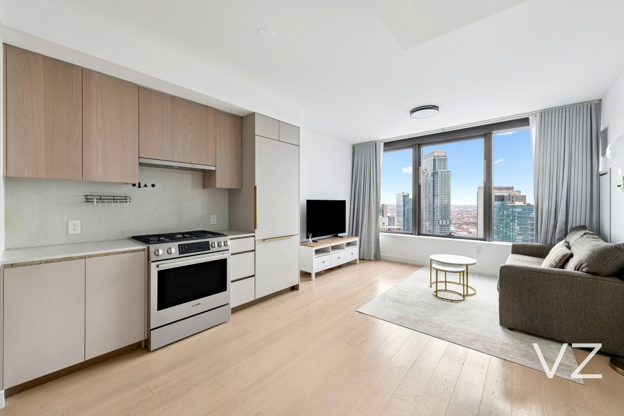 3 Court Square, Unit 5005 Queens, NY 11101 - Photo 2 of 8 a living room with furniture and a flat screen tv