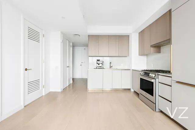 a kitchen with stainless steel appliances granite countertop a refrigerator and a stove top oven