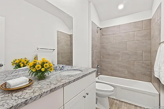 a bathroom with a granite countertop sink toilet and shower