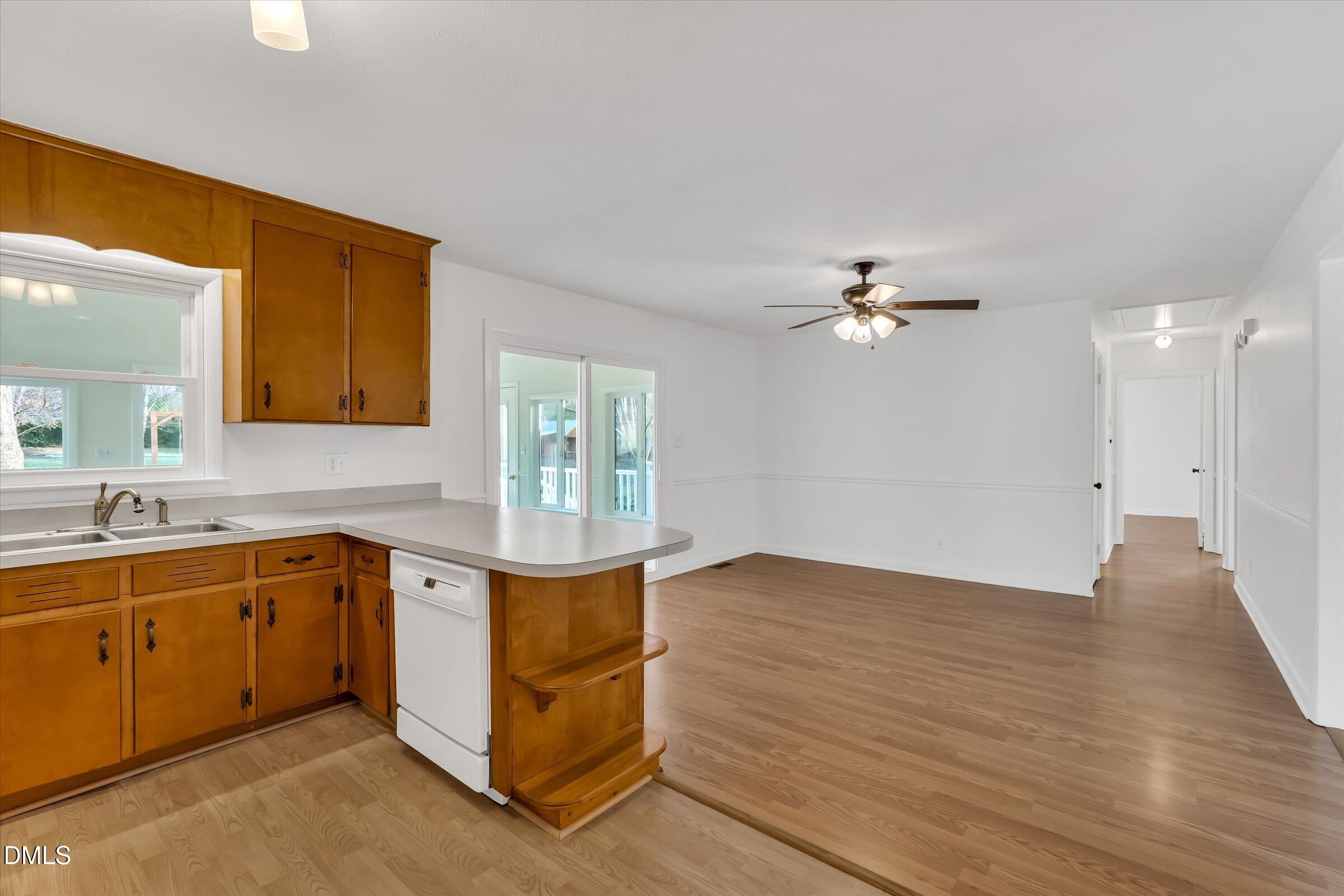4108 Campbell Road Raleigh, NC 27606 - Photo 11 of 42 a view of a kitchen with a sink and dishwasher cabinet with wooden floor