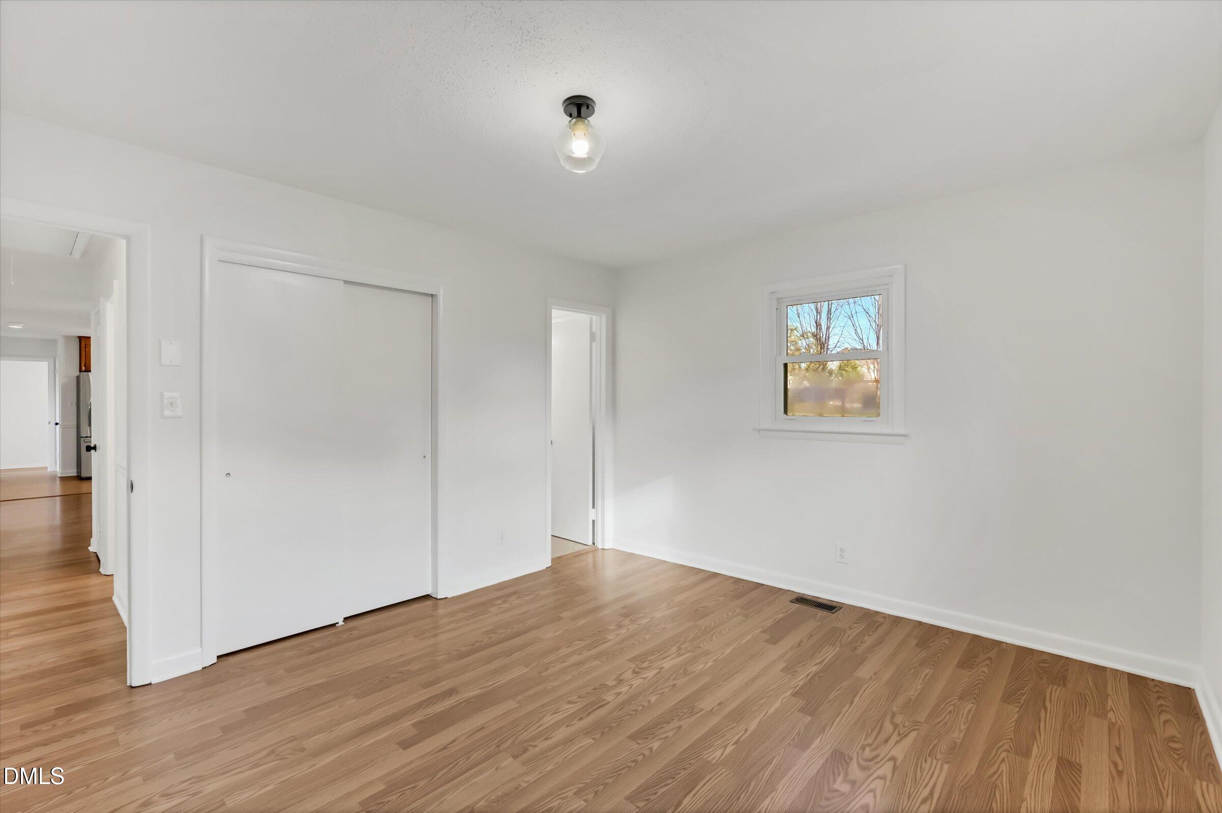 4108 Campbell Road Raleigh, NC 27606 - Photo 13 of 42 an empty room with wooden floor and window