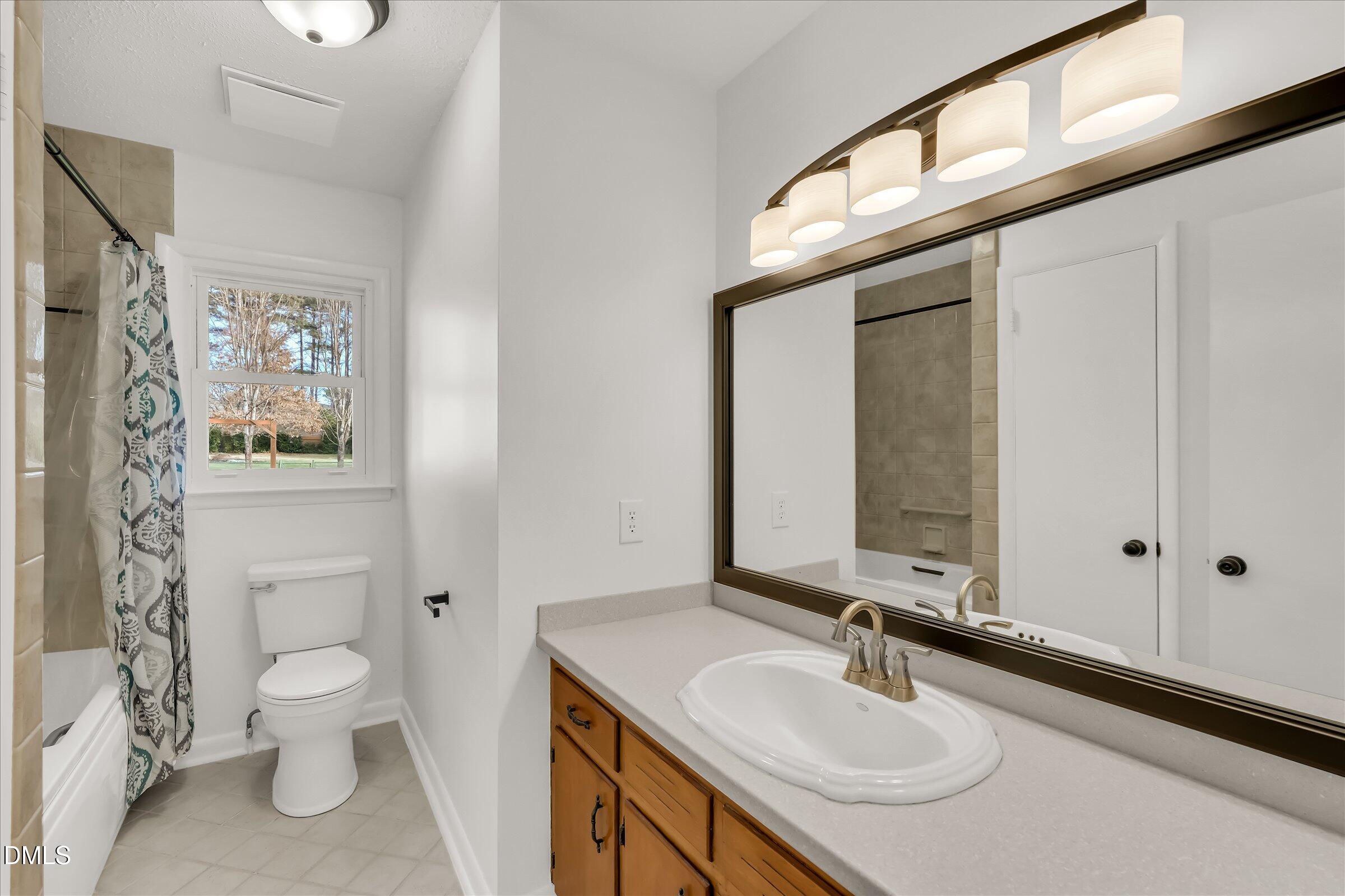 4108 Campbell Road Raleigh, NC 27606 - Photo 14 of 42 a bathroom with a granite countertop sink a toilet and a mirror