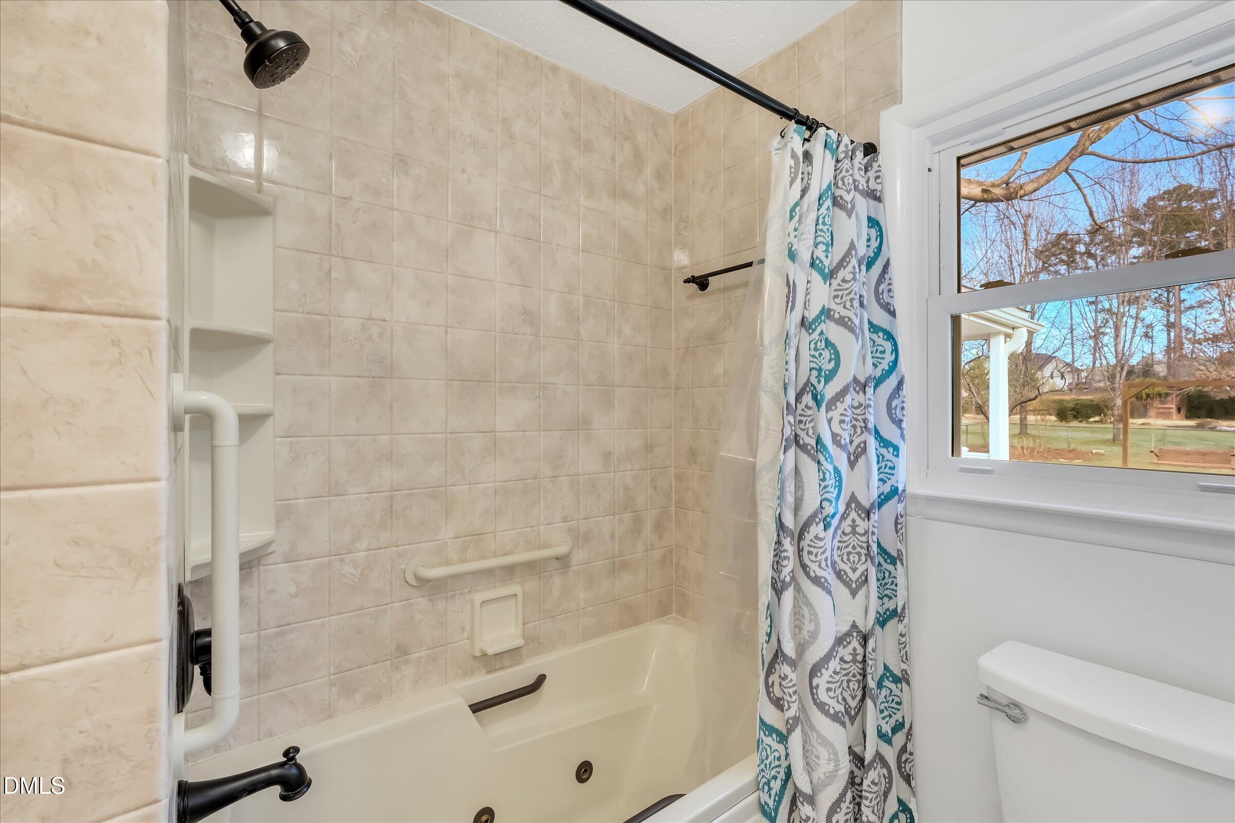 4108 Campbell Road Raleigh, NC 27606 - Photo 15 of 42 a bathroom with a shower curtain a bath tub and a shower curtain