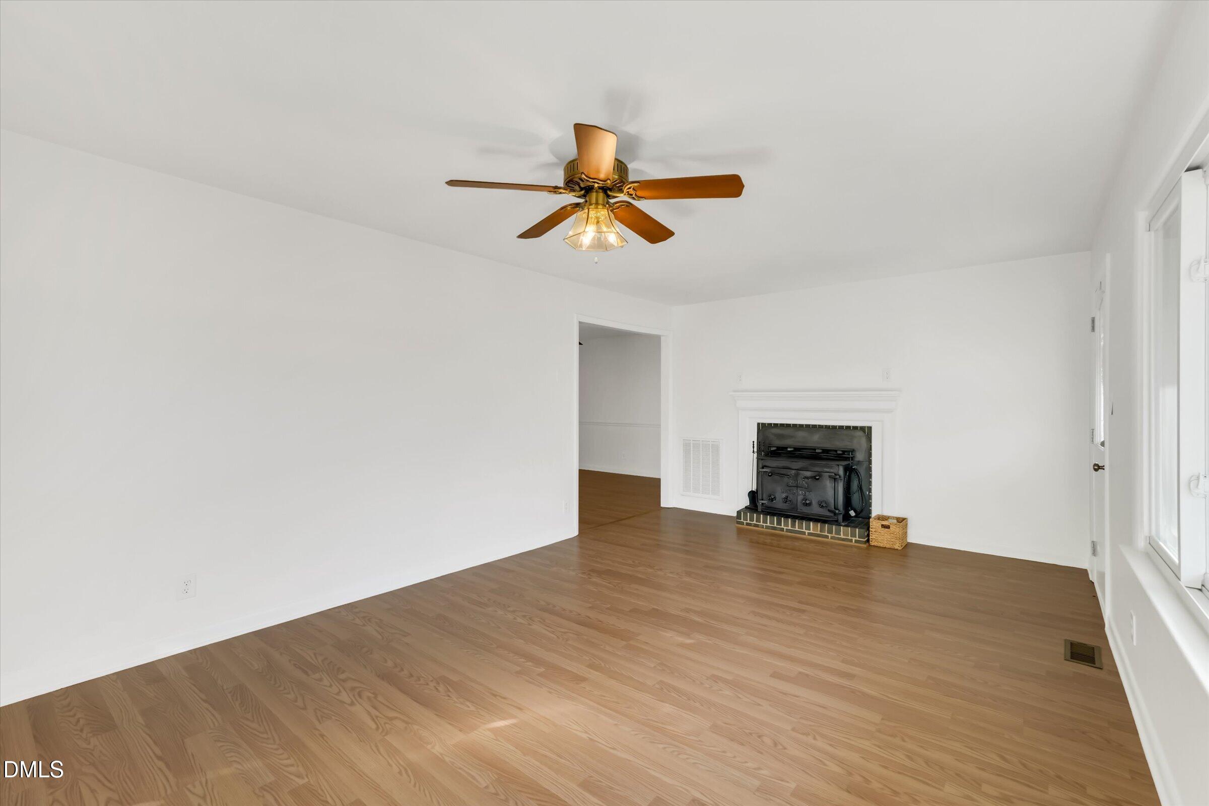 4108 Campbell Road Raleigh, NC 27606 - Photo 5 of 42 a view of empty room with wooden floor and fan