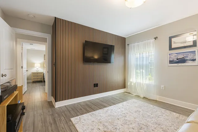a view of a livingroom with wooden floor and a flat screen tv