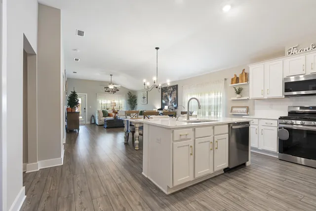 a kitchen with stainless steel appliances granite countertop a sink stove and wooden floor