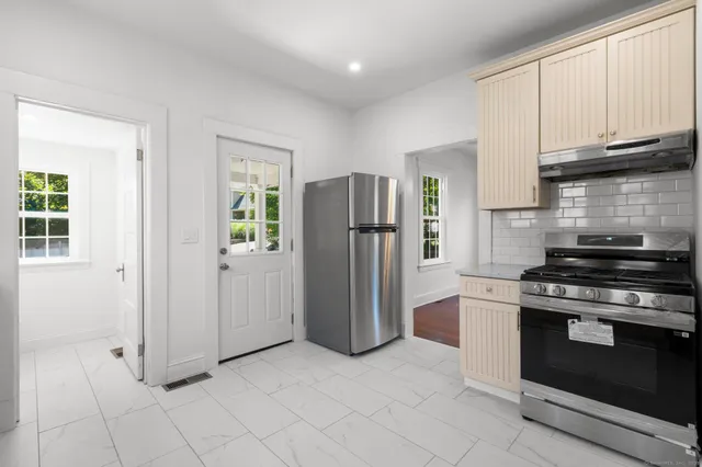 a kitchen with stainless steel appliances granite countertop a stove a refrigerator and a cabinets